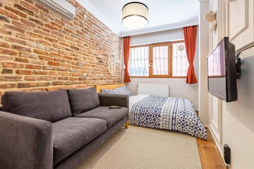 a living room with a couch and a brick wall at GALATA FİVE APARTMENTS in Istanbul