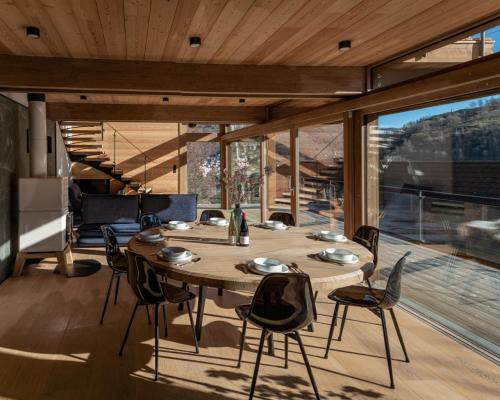 - une table et des chaises en bois dans une chambre avec une grande fenêtre dans l'établissement Chalet Fleur des Vosges 5 Bedrooms, à La Bresse