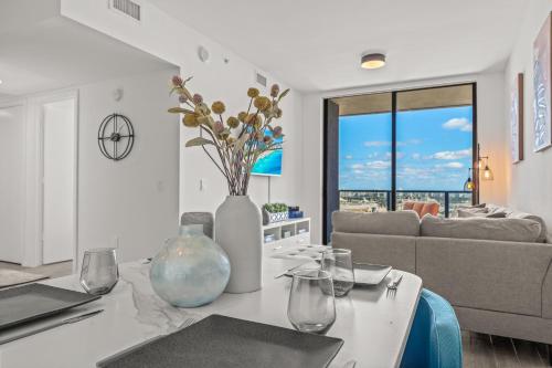 a white vase with flowers on a table in a living room at TR Miami 2 Bedroom, 1 Bedroom, and Studio Condos with Balconies in Miami