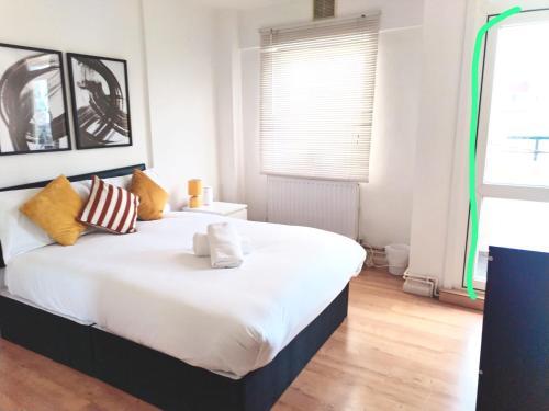 a bedroom with a large white bed with pillows at Central London rooms EC1V in London