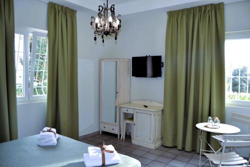 a bedroom with green curtains and a table and a desk at La Magnolia 140 in Fiumicino