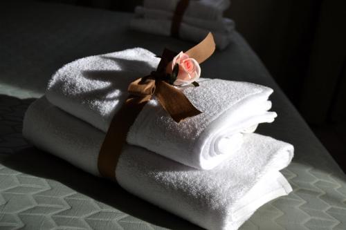 a stack of towels with a rose on top at La Magnolia 140 in Fiumicino