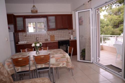 een keuken met een tafel en stoelen en een balkon bij Blue Lagoon in Loutraki