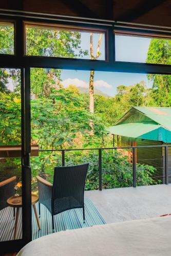a patio with two chairs and an umbrella at Arenal Getaway in Fortuna