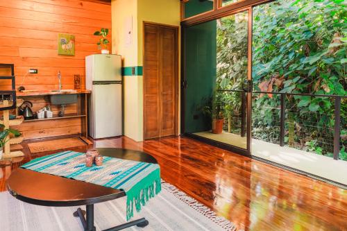 a kitchen with a table and a refrigerator in a room at Arenal Getaway in Fortuna