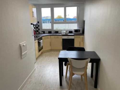uma cozinha com uma mesa e duas cadeiras num quarto em Appartement tout confort- face piscine Jeux Olympique 2024 em Laval