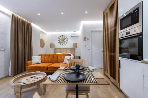Boho Central Apartment في تيرانا: غرفة معيشة مع أريكة وطاولة