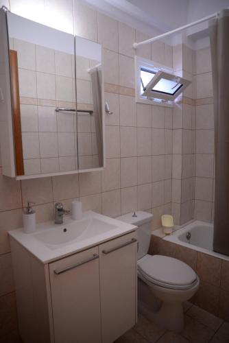 a bathroom with a toilet and a sink and a mirror at Blue Lagoon in Loutraki