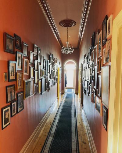 a hallway lined with pictures on the walls at The Red Door: Expansive Home/Pool/4 BR w Ensuites in Glenelg