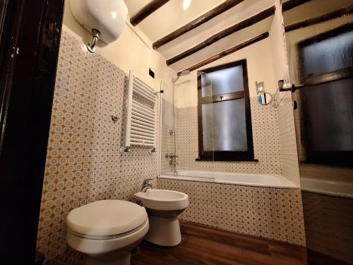 a bathroom with a toilet and a sink and a window at Ωlimpiα Apartment in Rome