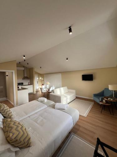 a bedroom with a large bed and a living room at Primeiro Quartel Apartments - 5 in Peso da Régua