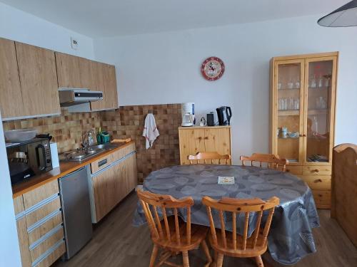 a kitchen with a table and chairs in a kitchen at Appartement résidence Les Dryades in Gérardmer