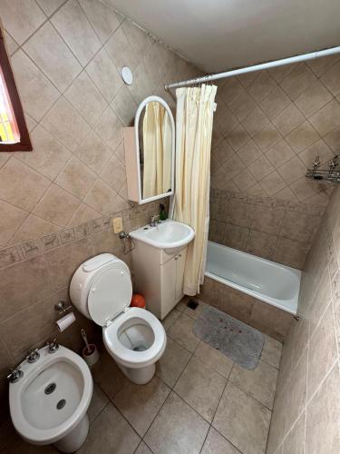 a small bathroom with a toilet and a sink at Casa Tilo in El Bolsón