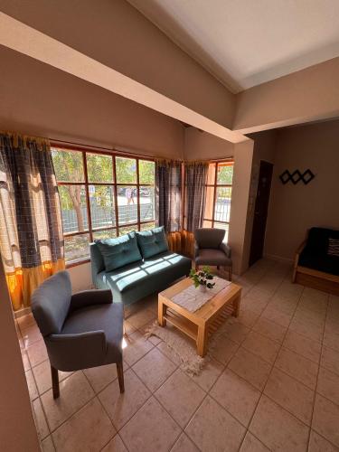 a living room with a couch and two chairs and a table at Casa Tilo in El Bolsón
