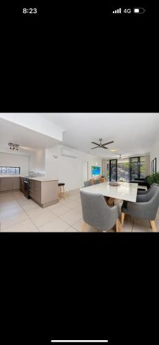 a kitchen and a living room with a table and chairs at 5 minute walk to the Stadium!! Taylord Holiday Homes and Apartments in Townsville
