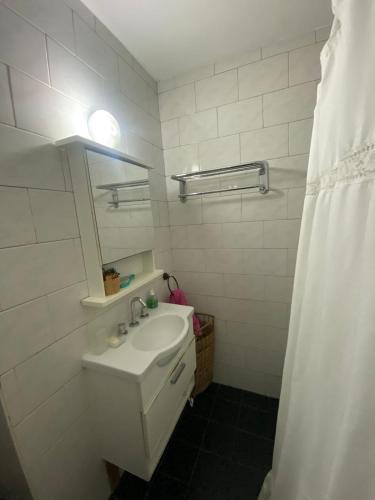 a white bathroom with a sink and a mirror at Un lugar cerca de todo in Buenos Aires