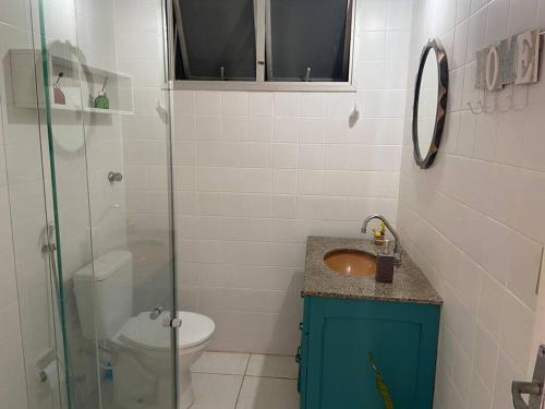 a bathroom with a sink and a glass shower at Apartamento bem localizado in Vitória