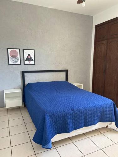 a blue bed with a blue bedspread in a bedroom at Apartamento bem localizado in Vitória