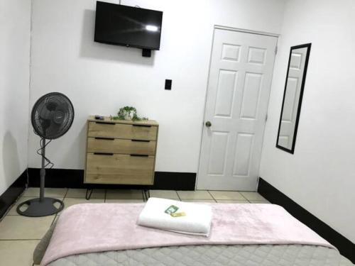 ein Schlafzimmer mit einem Bett, einem Ventilator und einer Kommode in der Unterkunft Casa Colibrí Apartamento 5 in Guatemala