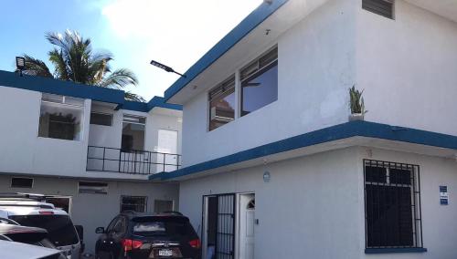 a white house with cars parked in front of it at Casa Colibrí Apartamento 5 in Guatemala