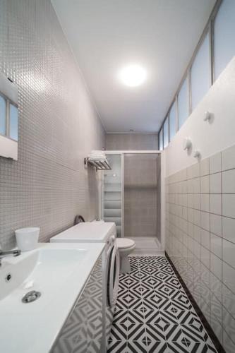 une salle de bain blanche avec un lavabo et des toilettes dans l'établissement En famille ou entre amis, à Mondelange