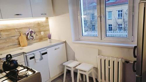 a small kitchen with a stove and a window at Magnolia1 in Toruń