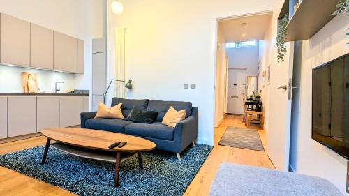 sala de estar con sofá azul y mesa en Luxury One Bedroom Apartment in the City Centre, en Edimburgo