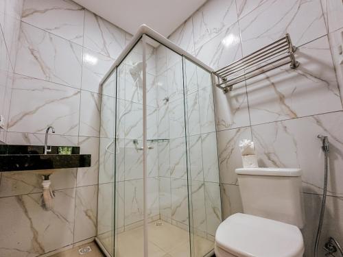 a bathroom with a toilet and a glass shower at Pousada Villa Barra Grande in Maragogi