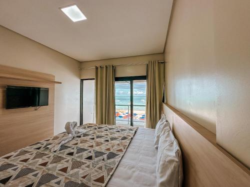 a bedroom with a bed with a view of the ocean at Pousada Villa Barra Grande in Maragogi