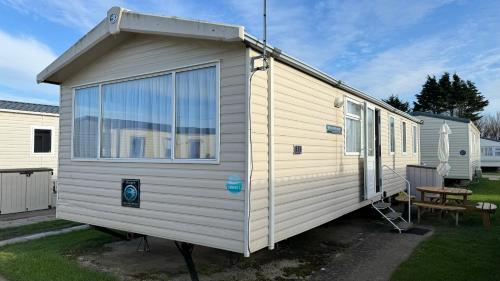 ein weißes winziges Haus in einem Hof in der Unterkunft Cozy Private Static Caravan at Llyons Robin Hood - Silver Birch Way 11 in Rhyl