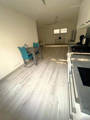 ein leeres Zimmer mit einem Tisch und einer Küche in der Unterkunft Blumwohnen in zentraler Lage in Filderstadt