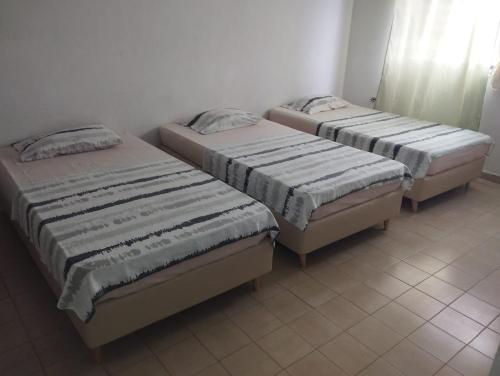 three beds sitting in a room with at Hotel Almirante Padilla in Ríohacha