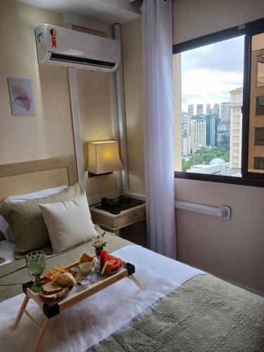 ein Hotelzimmer mit einem Tablett mit Essen auf dem Bett in der Unterkunft Flat Completo em Hotel 4 estrelas no Jardins! Com piscina, Jacuzzi, Sauna e academia! in São Paulo