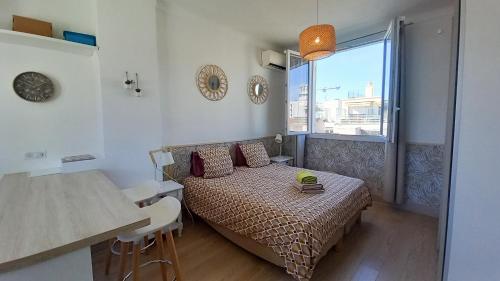 une petite chambre avec un lit et une table dans l'établissement Palais Gounod, à Cannes