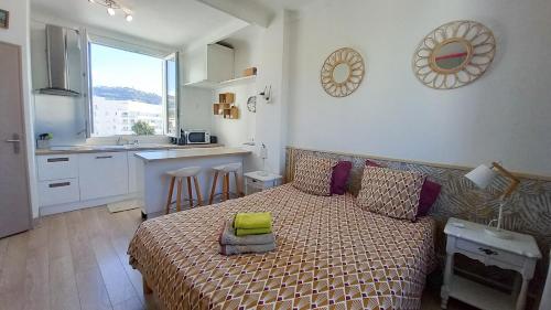 une petite chambre avec un lit et une cuisine dans l'établissement Palais Gounod, à Cannes