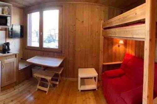 une chambre avec un canapé rouge et un lit mezzanine dans l'établissement Studio pour 3 personnes au pied des pistes, à La Salle Les Alpes