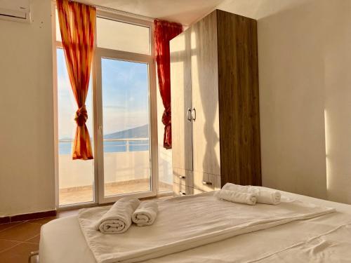 a bed in a room with a large window at Redi's Seaview Apartments in Sarandë