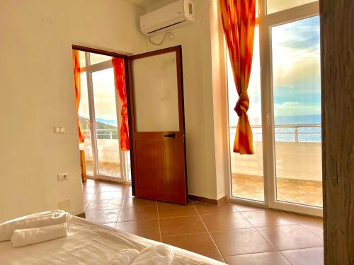 a bedroom with a bed and a view of the ocean at Redi's Seaview Apartments in Sarandë