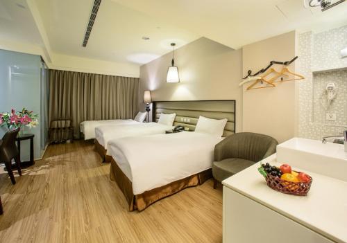 a hotel room with two beds and a sink at Stay Hotel - Taichung Yizhong in Taichung