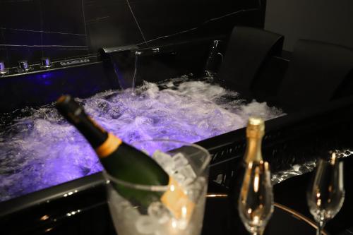 butelka szampana jest w wannie z wodą w obiekcie 115 Luxury Suite - Privitera w mieście Grammichele