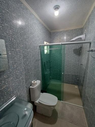 a bathroom with a toilet and a glass shower at Suíte com vista panorâmica in Bombinhas