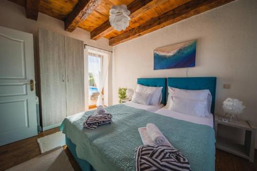 - une chambre avec un lit bleu et des serviettes dans l'établissement Villa Mani, à Butkovići
