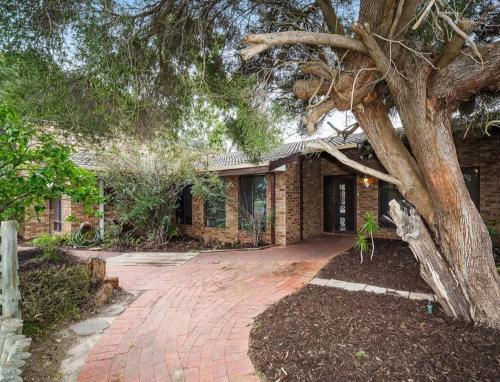 a brick house with a tree in front of it at Queen Size Bedroom Near Sawn River in Perth