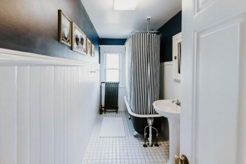 a bathroom with a tub and a sink at Retro Gem Box Victorian Steps from Irvine Park in Saint Paul