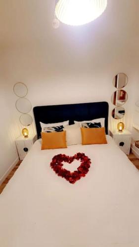 almohada en forma de corazón en una cama en un dormitorio en Gite avec jacuzzi privé en Arnières-sur-Iton