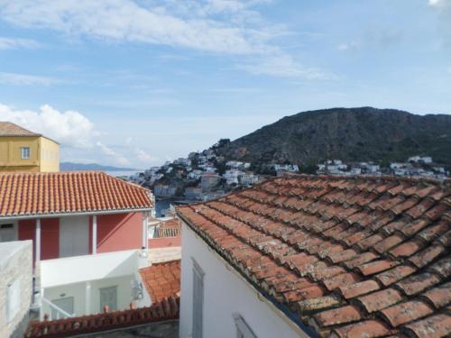 a view of the roofs of buildings and a mountain at In the heart of Hydra in Hydra