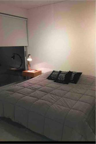 a bedroom with a bed and a table with a lamp at Excelente estudio premium con amenities in Buenos Aires