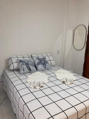 Una cama con toallas en una habitación en Pousada Bella Flor en Baía Formosa