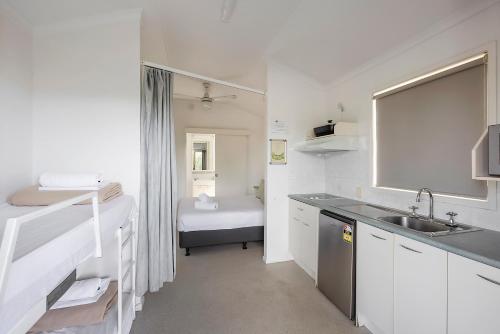 a small white kitchen with a sink and a sink at Reflections Lennox Head - Holiday Park in Lennox Head