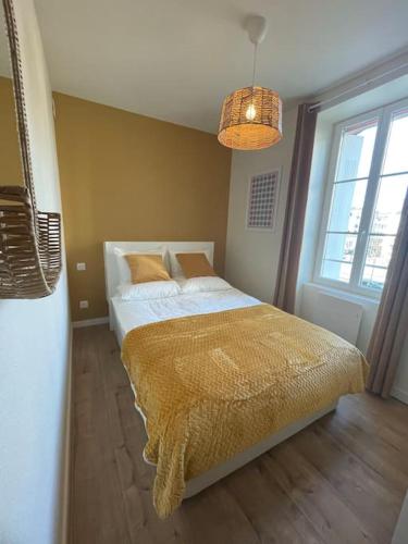 ein Schlafzimmer mit einem Bett mit einer goldenen Decke darauf in der Unterkunft Apartment Heart of Rennes Private Parking in Rennes